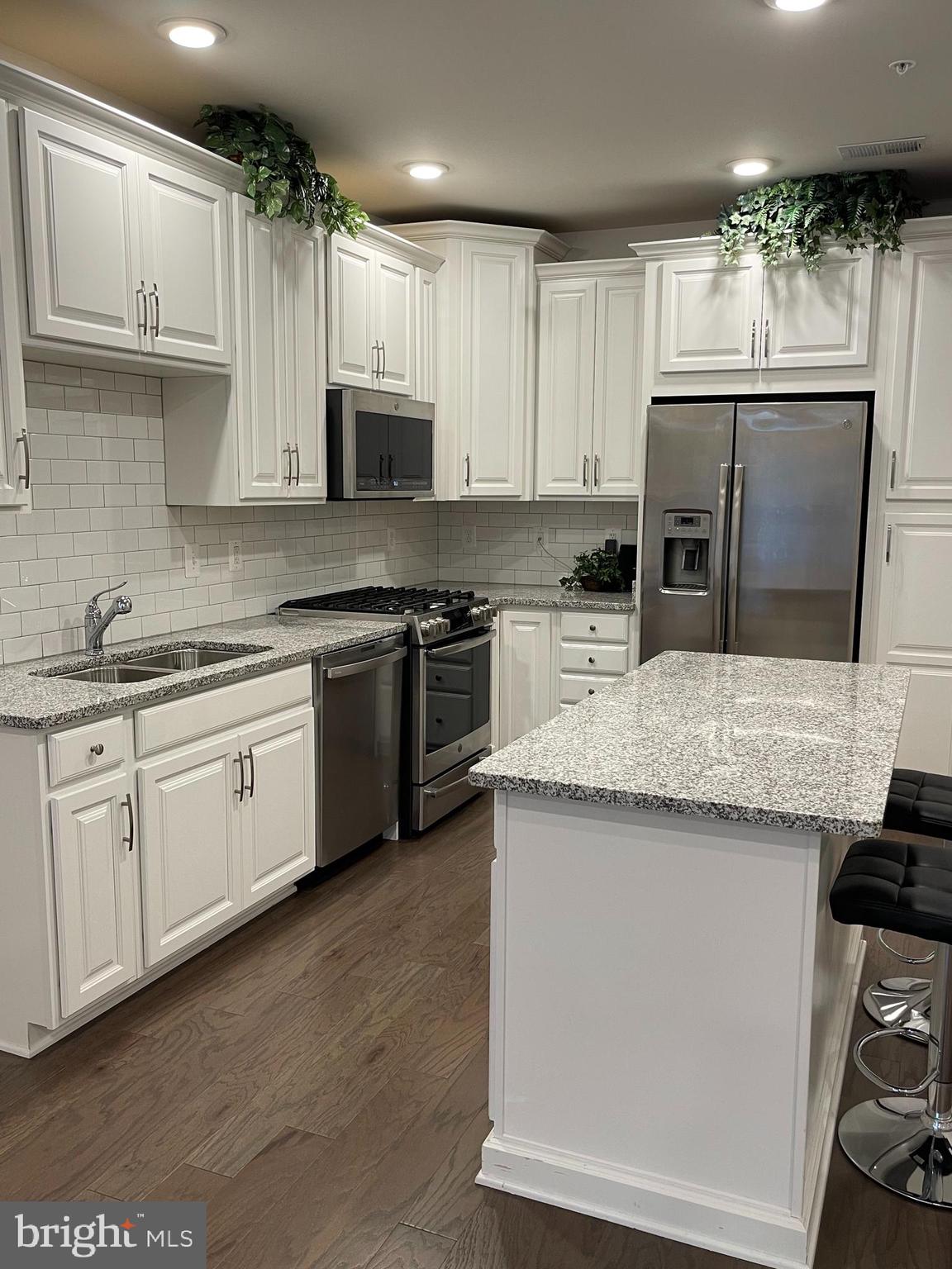 a kitchen with stainless steel appliances granite countertop a sink stove microwave and cabinets