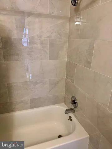 a bath tub sitting next to a white sink and a shower
