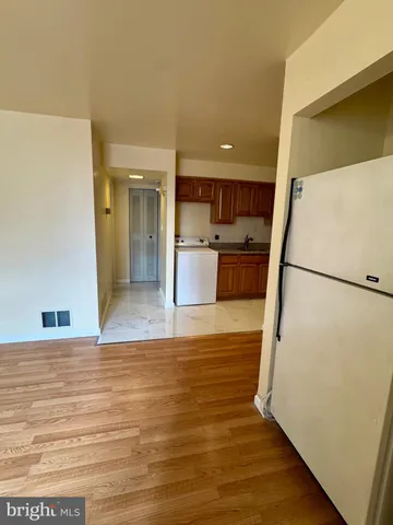 a view of a kitchen with furniture and a refrigerator
