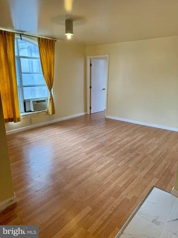 an empty room with wooden floor and stairs
