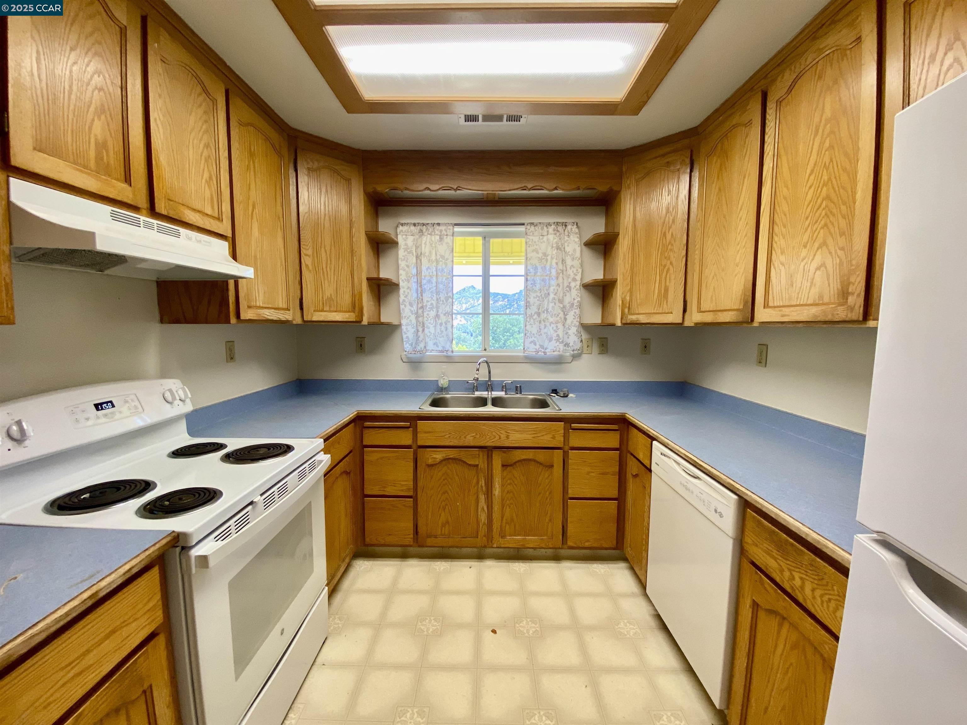 2707 River View Road Clearlake Oaks, CA 95423 - Photo 7 of 18 a kitchen with a sink a stove cabinets and wooden floor