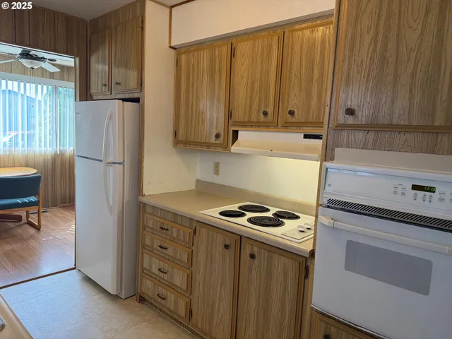 a kitchen with granite countertop cabinets and refrigerator stove