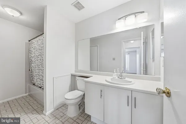 a bathroom with a granite countertop sink a toilet and a mirror
