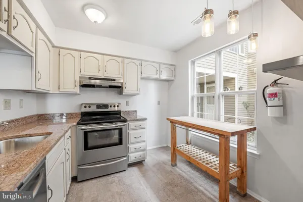a kitchen with stainless steel appliances granite countertop a stove and a sink
