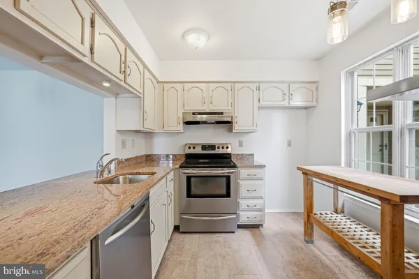 a kitchen with granite countertop a stove and a sink