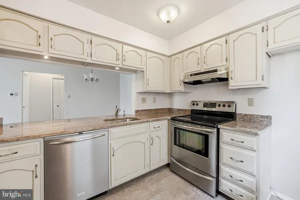 a kitchen with stainless steel appliances granite countertop a sink and cabinets
