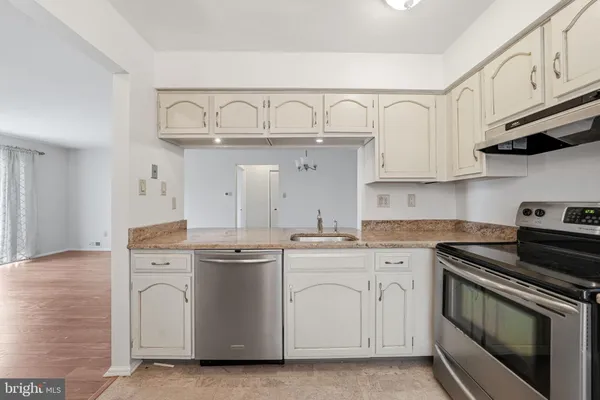 a kitchen with white cabinets and white appliances