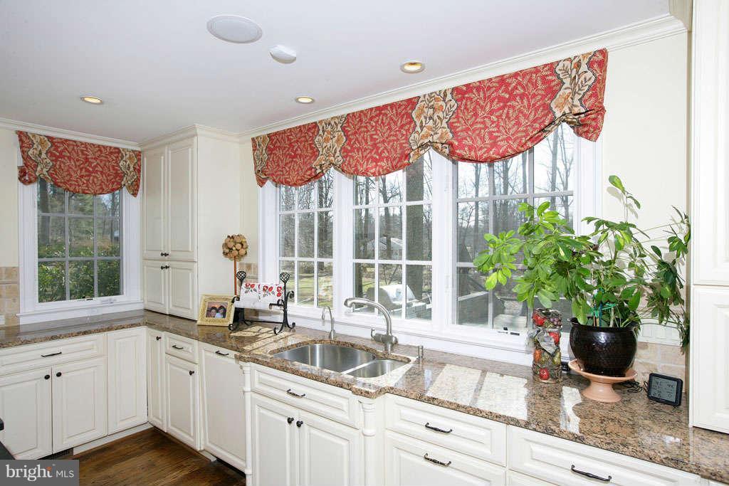 10820 Lockland Road Potomac, MD 20854 - Photo 14 of 30 a kitchen with stainless steel appliances granite countertop a sink a large window and a potted plant