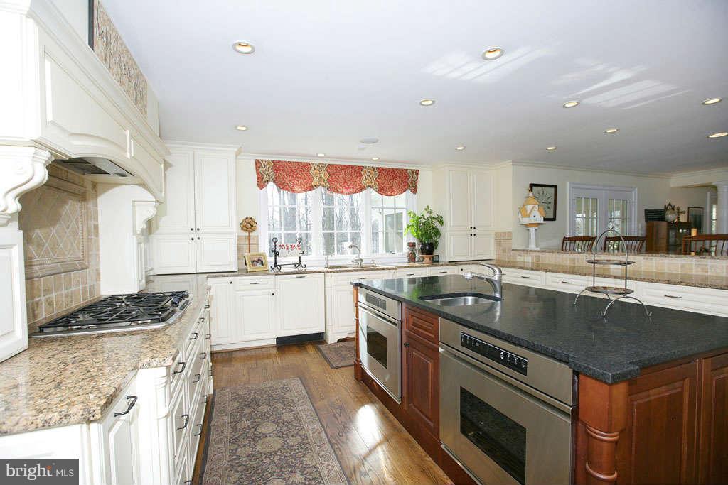 10820 Lockland Road Potomac, MD 20854 - Photo 16 of 30 a kitchen with stainless steel appliances granite countertop a sink stove and cabinets