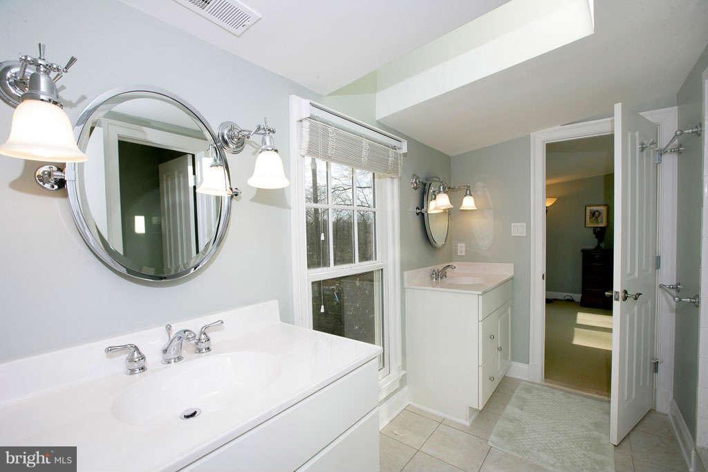 10820 Lockland Road Potomac, MD 20854 - Photo 27 of 30 a bathroom with a double vanity sink mirror and bathtub