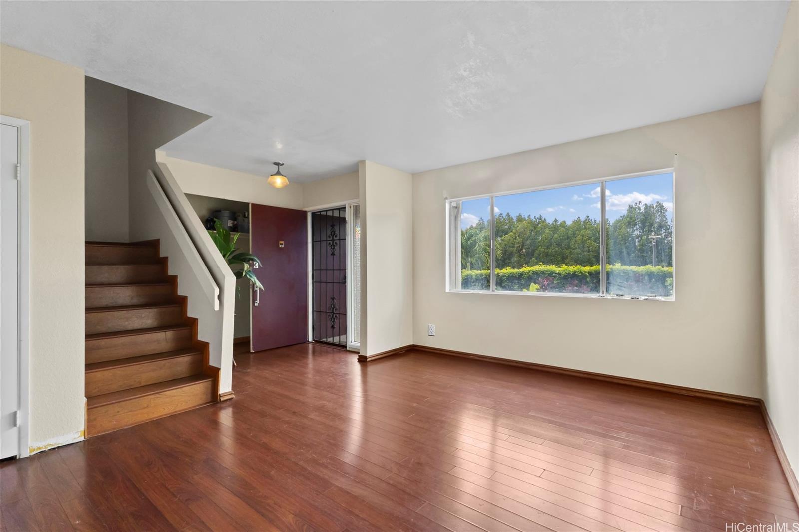92-1226 Makakilo Drive, Unit 6 Kapolei, HI 96707 - Photo 7 of 15 a view of an empty room with wooden floor and a window