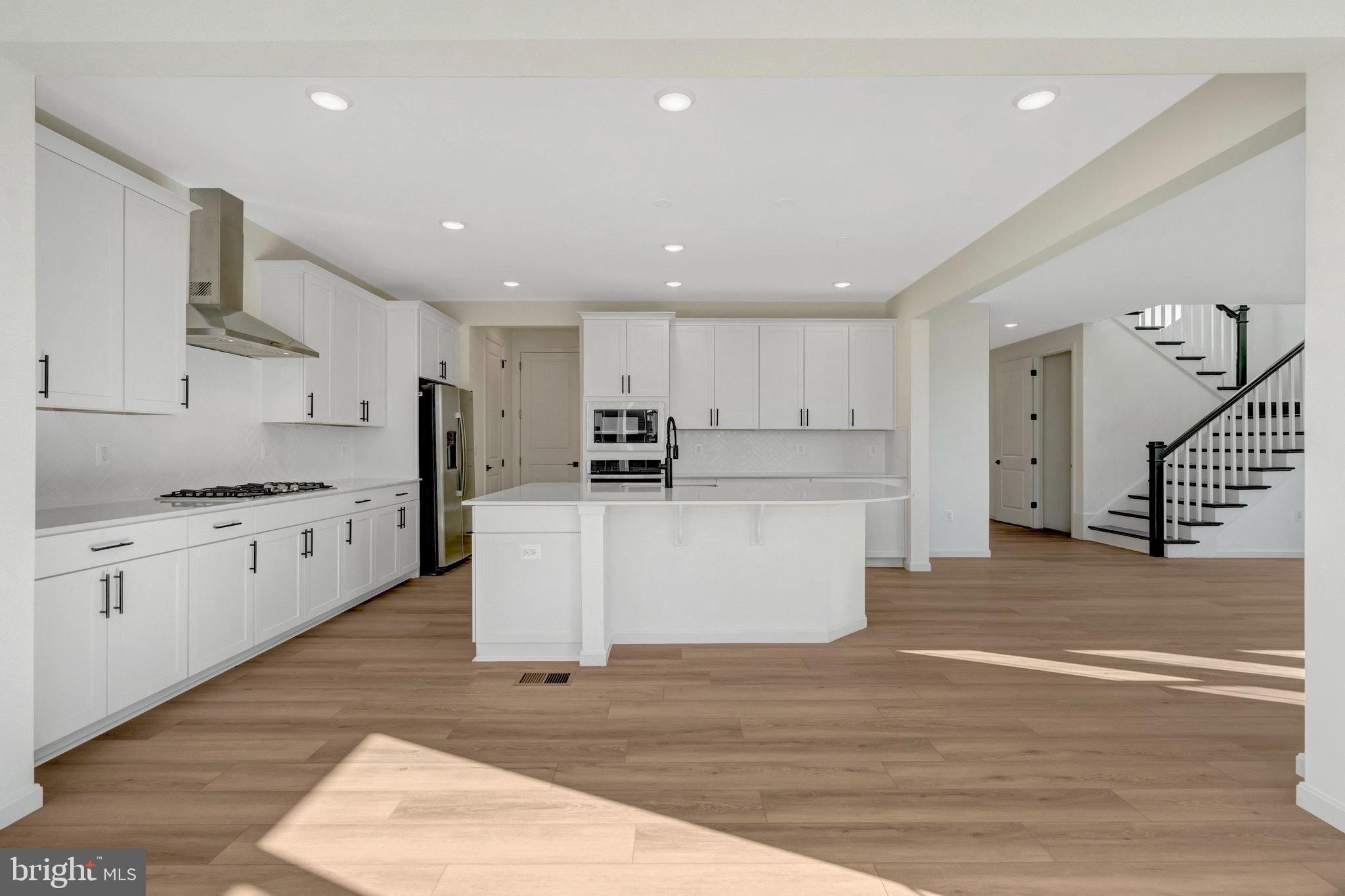 1925 Sunset Lane Culpeper, VA 22701 - Photo 21 of 74 a large kitchen with stainless steel appliances kitchen island a stove a refrigerator a sink dishwasher a oven and white cabinets with wooden floor