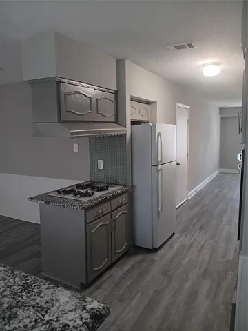 a kitchen with stainless steel appliances granite countertop a refrigerator and a stove top oven