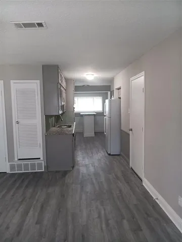 a view of a kitchen with wooden floor and electronic appliances