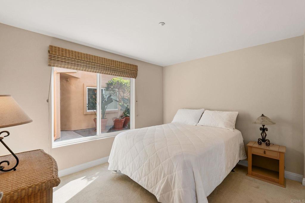 400 The Strand North, Unit 7 Oceanside, CA 92054 - Photo 24 of 35 a bedroom with a large bed and a large window