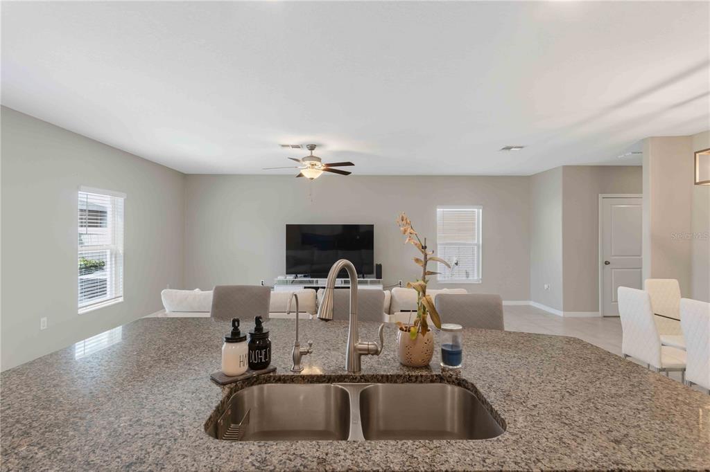 9440 Lemon Drop Loop Sun City Center, FL 33573 - Photo 13 of 55 a kitchen with a sink cabinets and chandelier