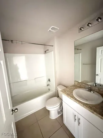 a bathroom with a granite countertop sink toilet a mirror and shower