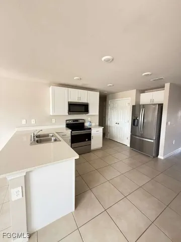 a kitchen with stainless steel appliances a refrigerator sink and cabinets