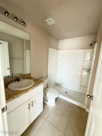a bathroom with a granite countertop sink toilet and shower