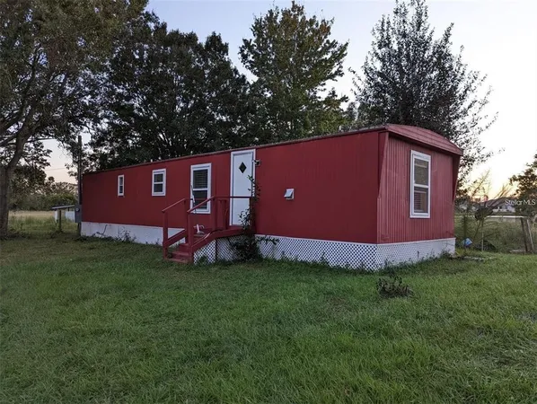 a view of a backyard with potted plants and large trees