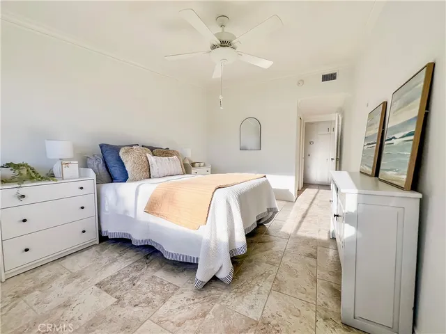 a spacious bedroom with a bed and a chandelier