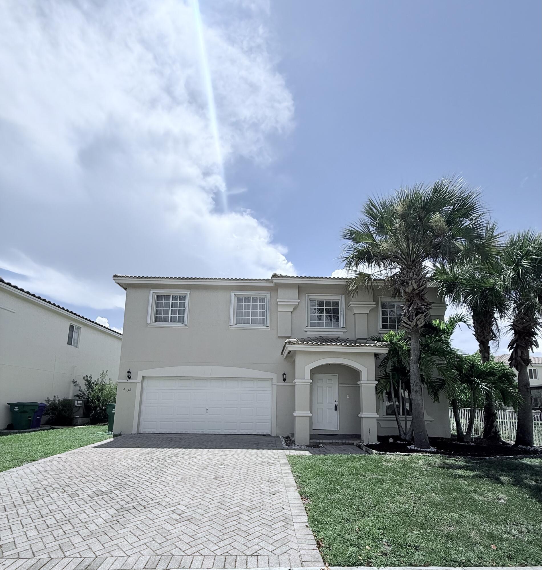 4534 Southwest 127th Terrace Miramar, FL 33027 - Photo 1 of 45 front view of a house with a garden and trees