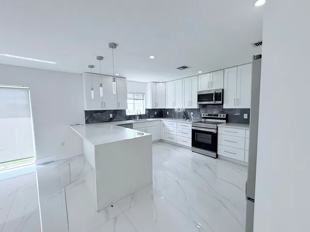 a large kitchen with cabinets stainless steel appliances and a counter space