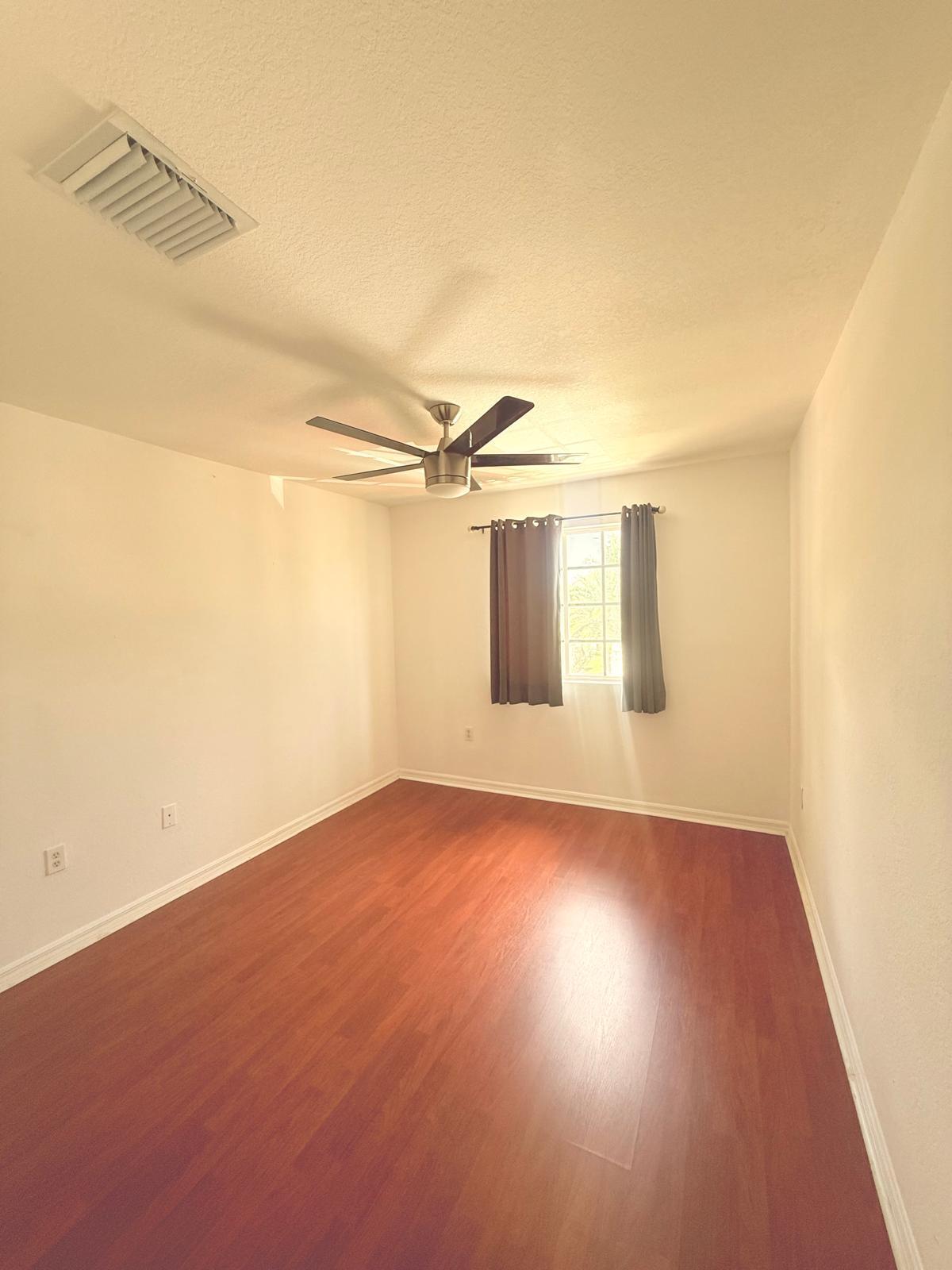 4534 Southwest 127th Terrace Miramar, FL 33027 - Photo 18 of 45 an empty room with wooden floor and windows