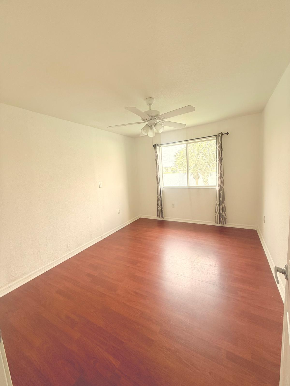 4534 Southwest 127th Terrace Miramar, FL 33027 - Photo 23 of 45 an empty room with wooden floor and windows