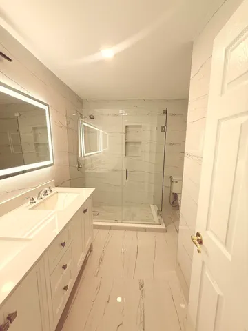 a bathroom with a shower sink and mirror