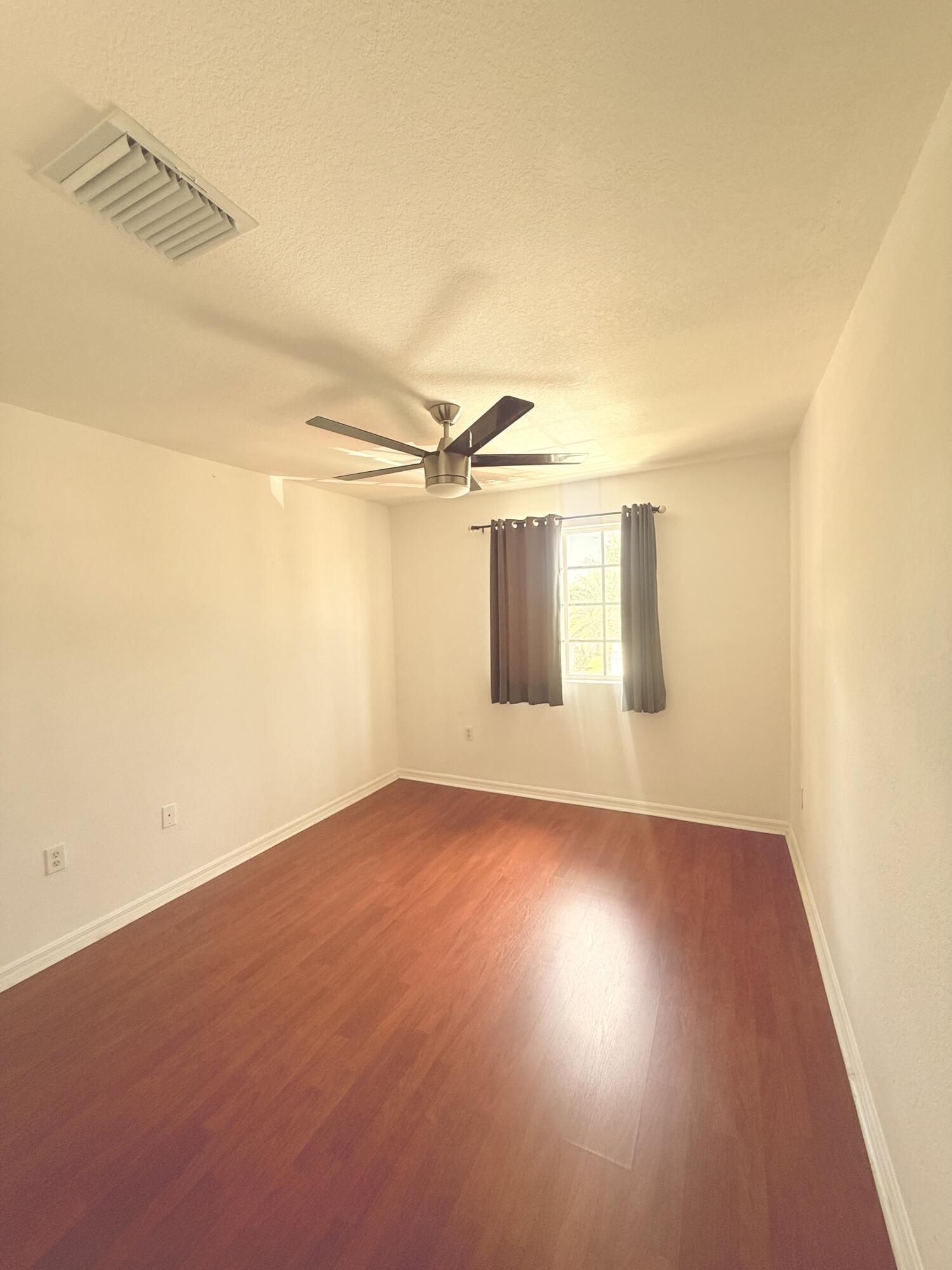 4534 Southwest 127th Terrace Miramar, FL 33027 - Photo 38 of 45 an empty room with wooden floor and windows