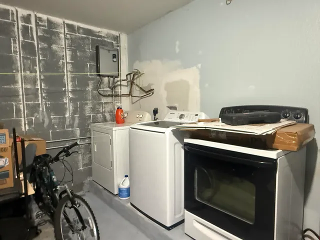 a utility room with dryer washer and a view of living room