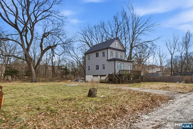 a view of large house with a yard covered with snow in front of house