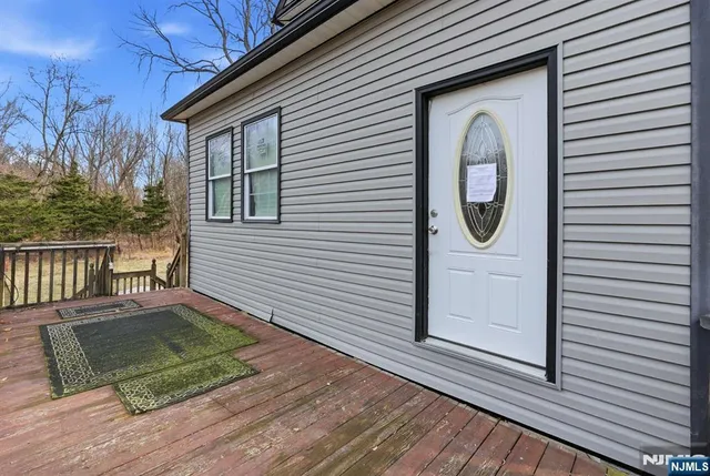 a view of a house with wooden floor chairs and wooden fence