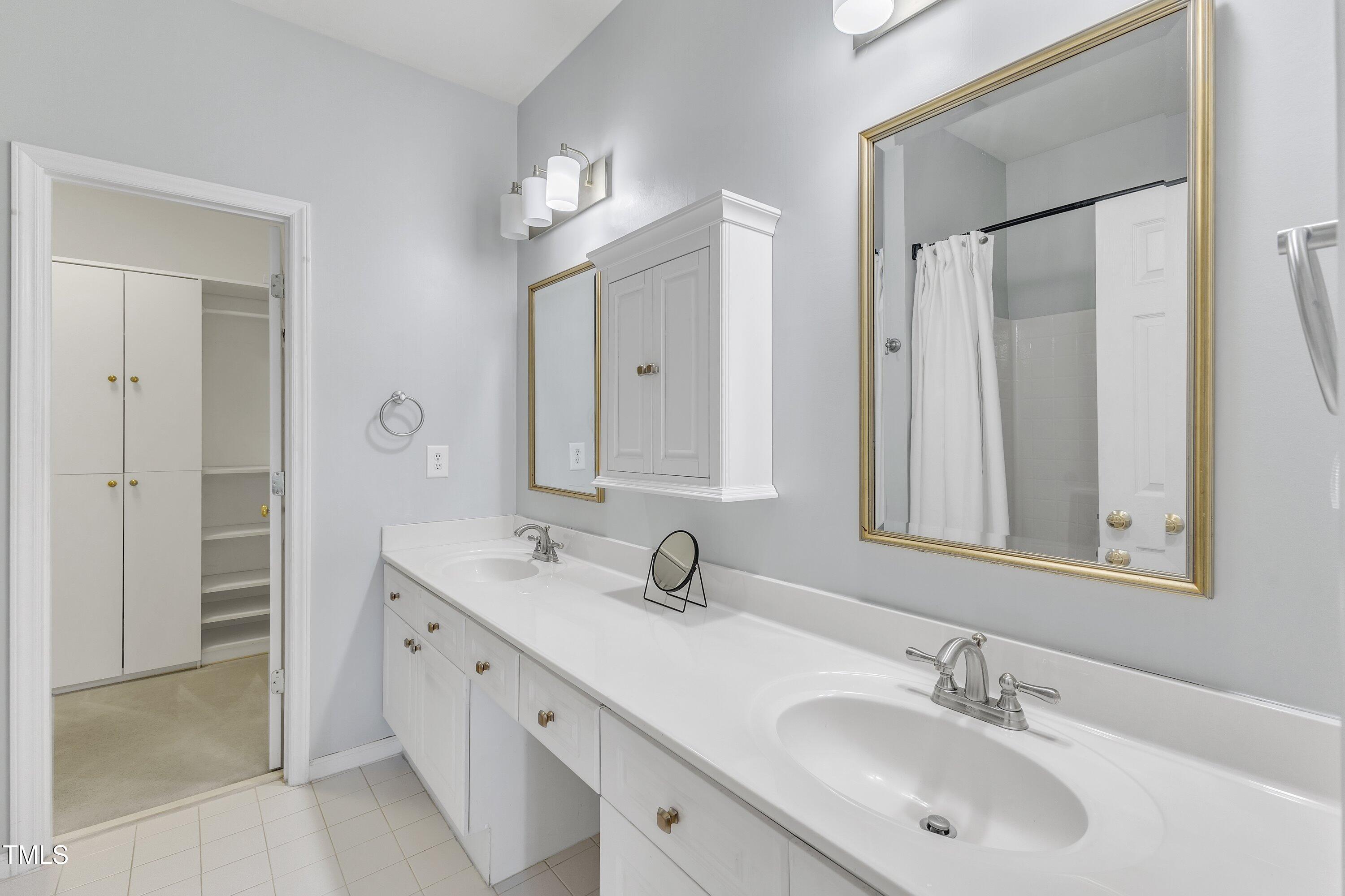1201 Red Beech Court Raleigh, NC 27614 - Photo 21 of 41 Primary bathroom, with garden tub/shower, dual vanities, and walk in closet with drawers and shelving