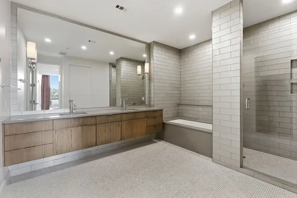 a bathroom with a granite countertop sink a toilet a mirror and bathtub