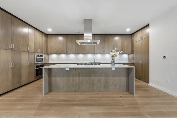 a kitchen with kitchen island a counter top stainless steel appliances and cabinets