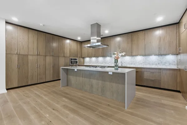 a kitchen with kitchen island granite countertop a sink cabinets and stainless steel appliances