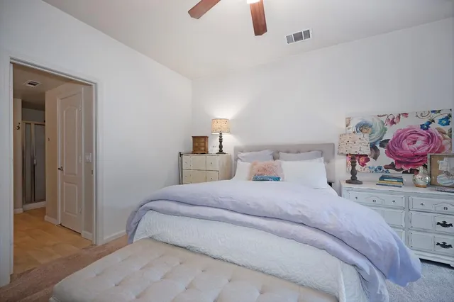 a bedroom with a bed and painting on the wall