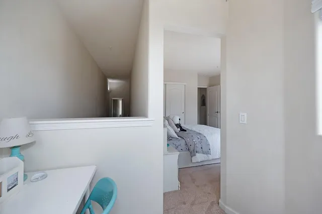 a bedroom with a bed and a potted plant on the dresser