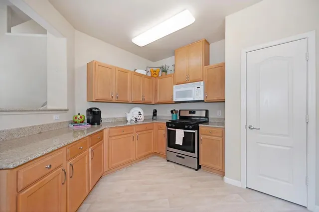 a kitchen with granite countertop a stove top oven sink and cabinets