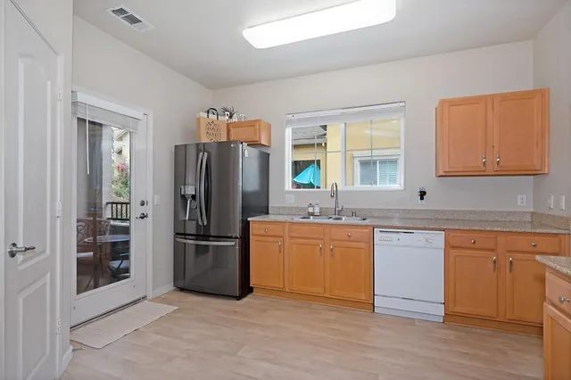 a kitchen with stainless steel appliances granite countertop a refrigerator and a sink