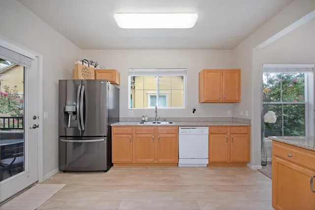 a kitchen with stainless steel appliances granite countertop a refrigerator and a sink