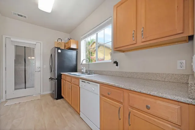 a kitchen with stainless steel appliances granite countertop a refrigerator and a sink
