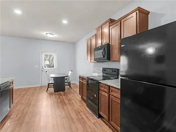 a kitchen with granite countertop a stove a sink and a refrigerator
