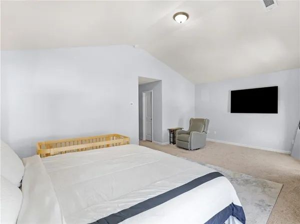 a bedroom with a bed and a flat screen tv