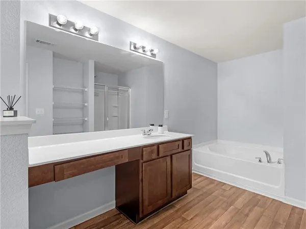 a bathroom with a bathtub a sink and a mirror