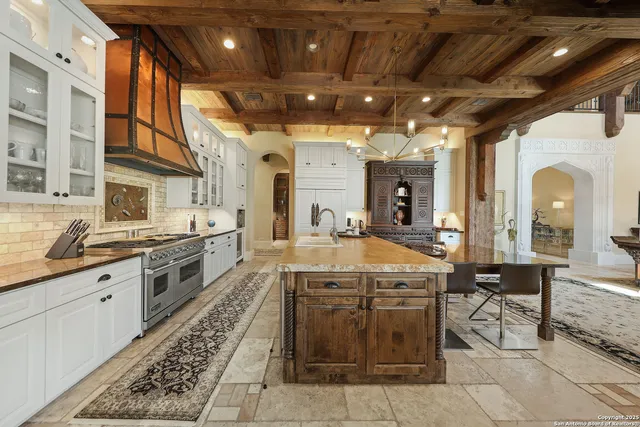 a large kitchen with stainless steel appliances granite countertop a stove and cabinets