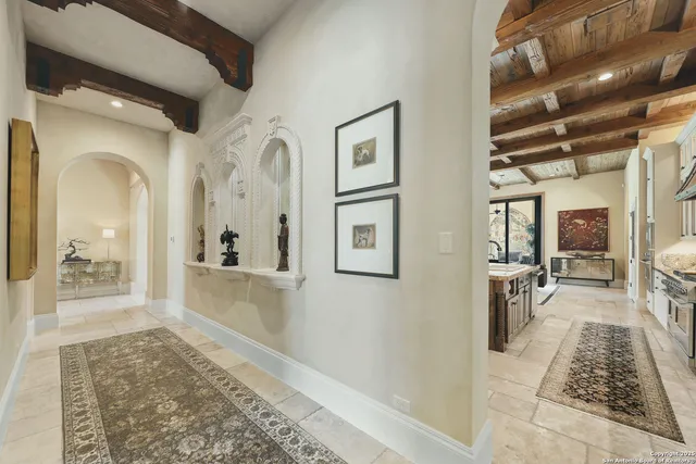 a hallway with wooden floor chandelier and living room
