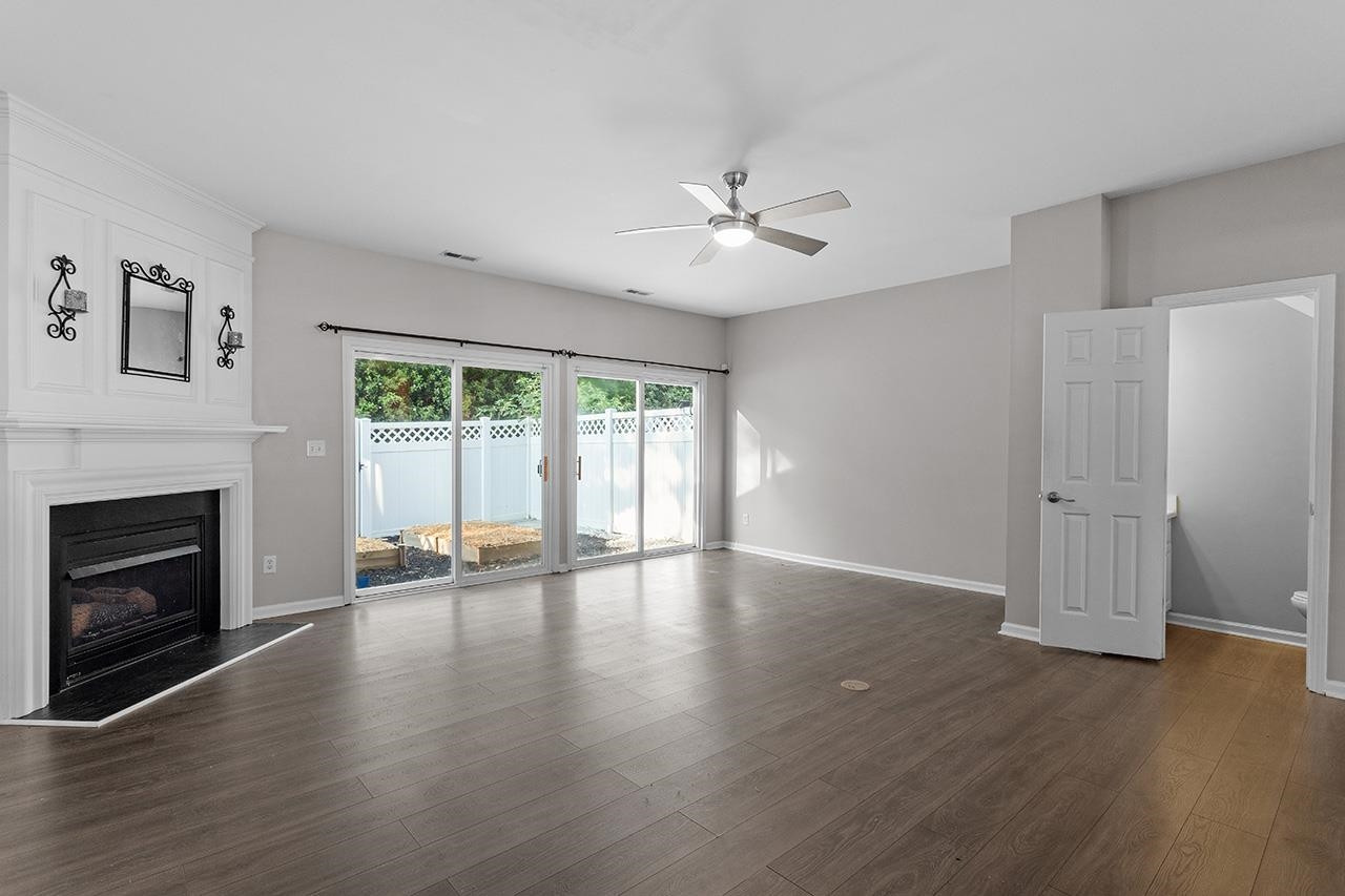 5343 Glen Canyon Road Raleigh, NC 27616 - Photo 8 of 17 a view of an empty room with wooden floor and a fireplace